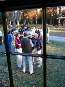 Seen through the window of restored Stockton School, groups outside are engaged in conversation with Boykin area residents.